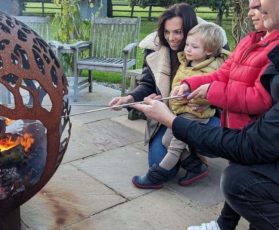 Family with young children toasting marshmallows