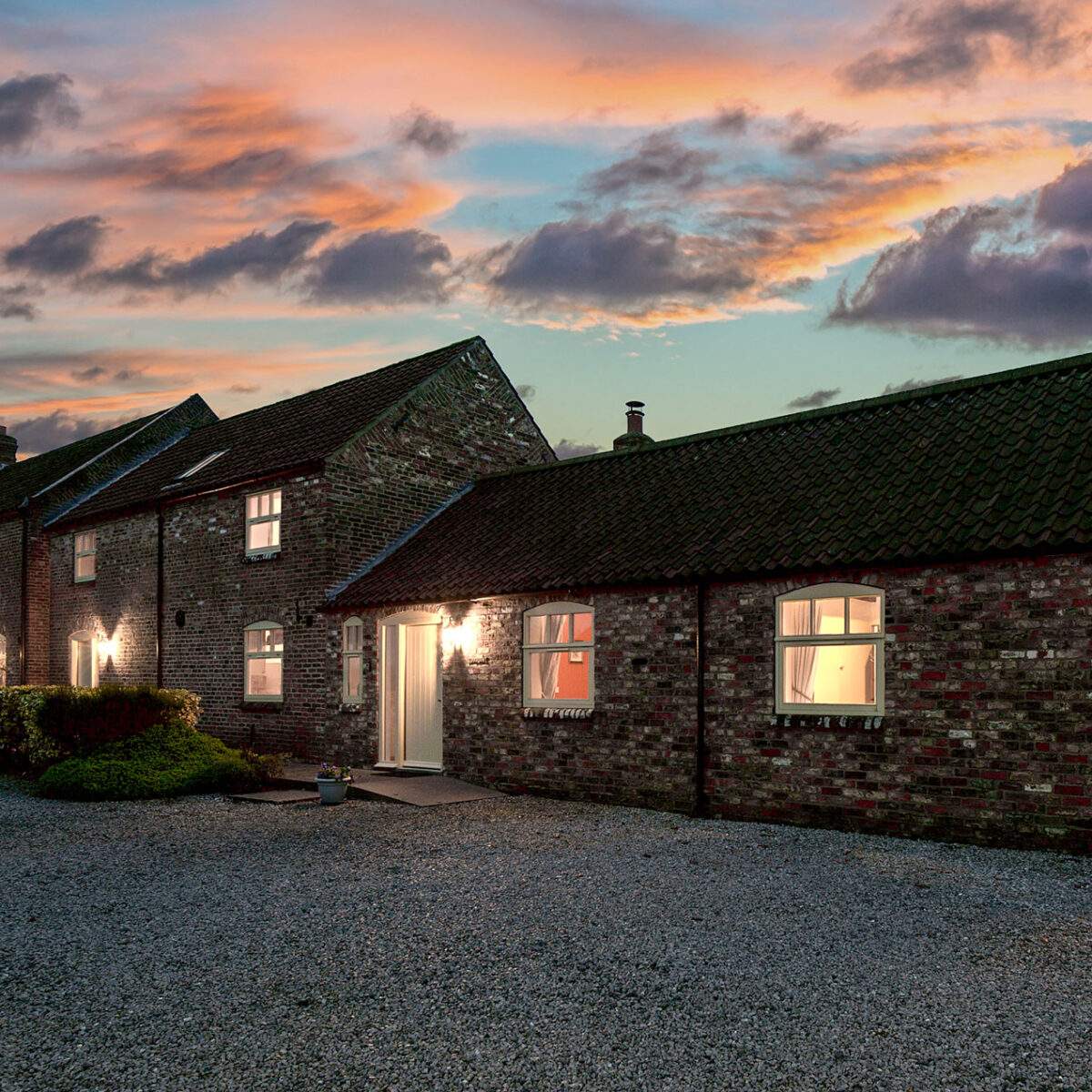 brick cottages all lit up at night as dusk turns 