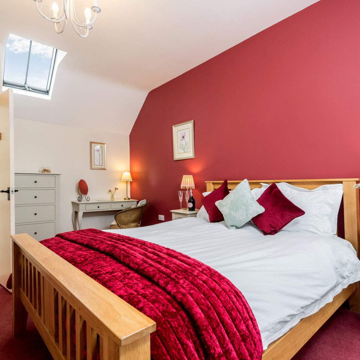 king bed flooded with light and a door open to ensuite shower room 