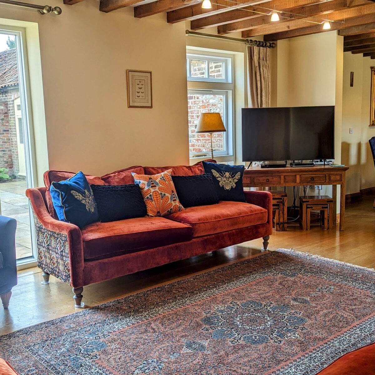 comfortable sofas and a big tv in the living room with a dining table in the background 