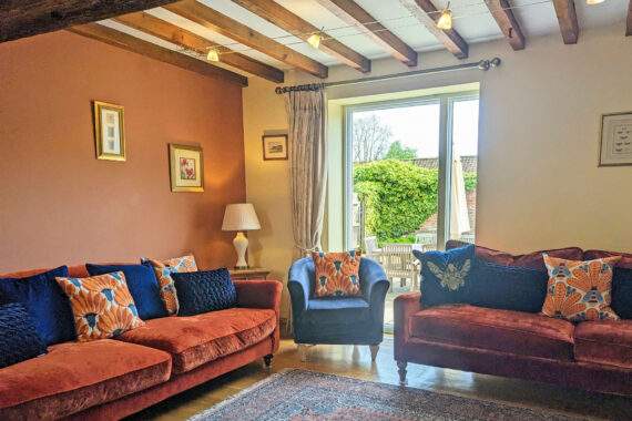 sitting room with large window looking onto a garden 