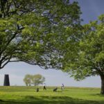 golfers playing on the golf course at Beverley westwood with one of the black mills in the background