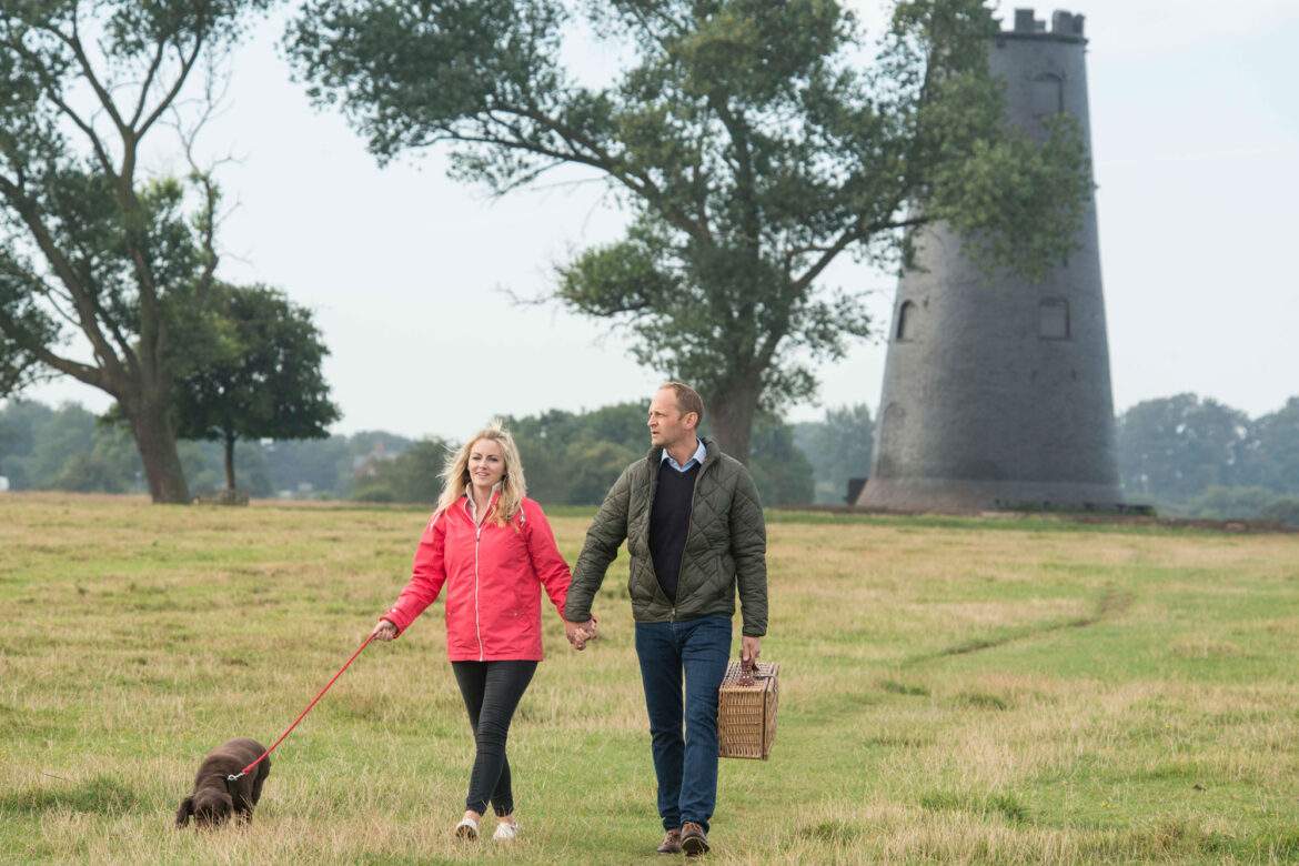 a couple walking by black mill on beverley westwood