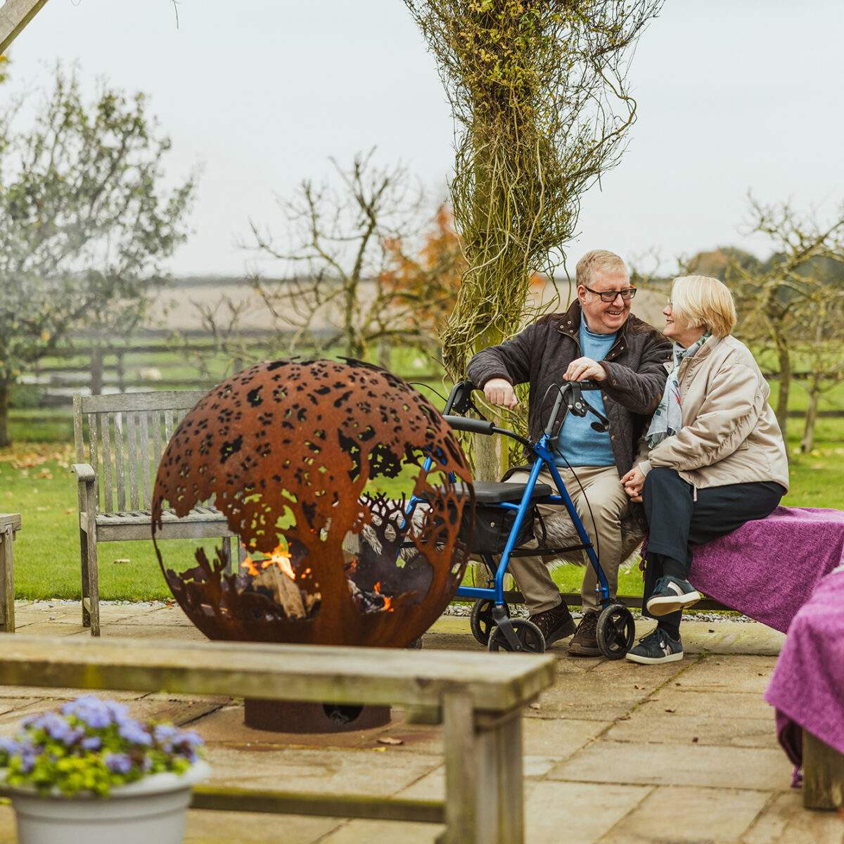 Broadgate_Farm_Cottages_180 Older couple sitting by the fireball in autumn - man uses a mobility aid