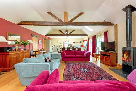 Large open plan area with comfortable seating and kitchen in the background 