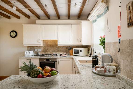 cream kitchen with granite worktop and a bowl of fruit 