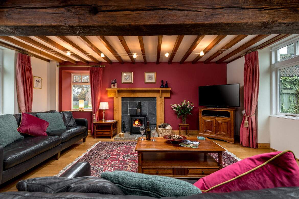 large living room with leather sofas and log burner