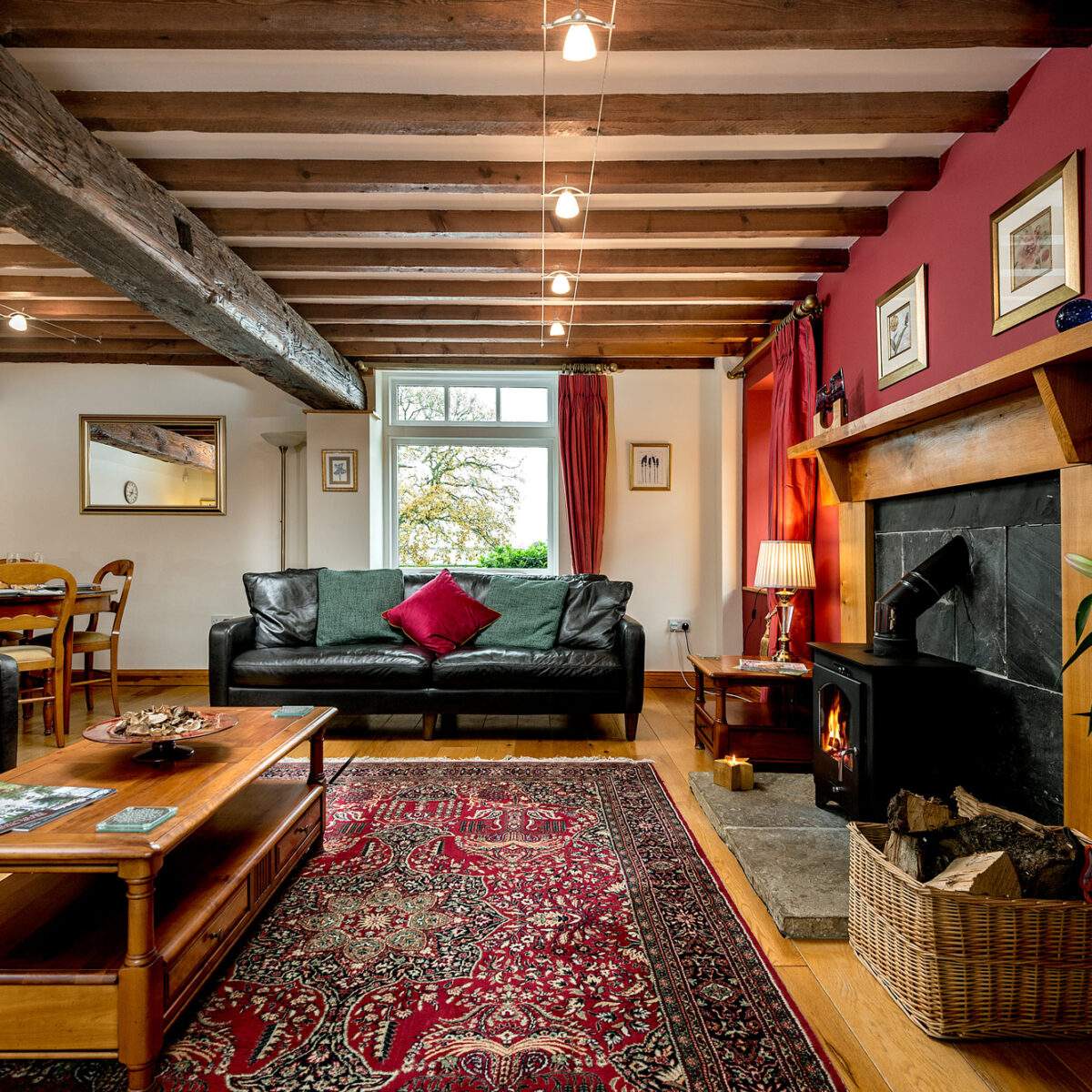 Living room with a wood burner, comfortable sofas and dining area in the corner 