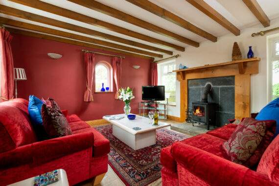 Light and airy living room with comfortable sofas and a wood burner 