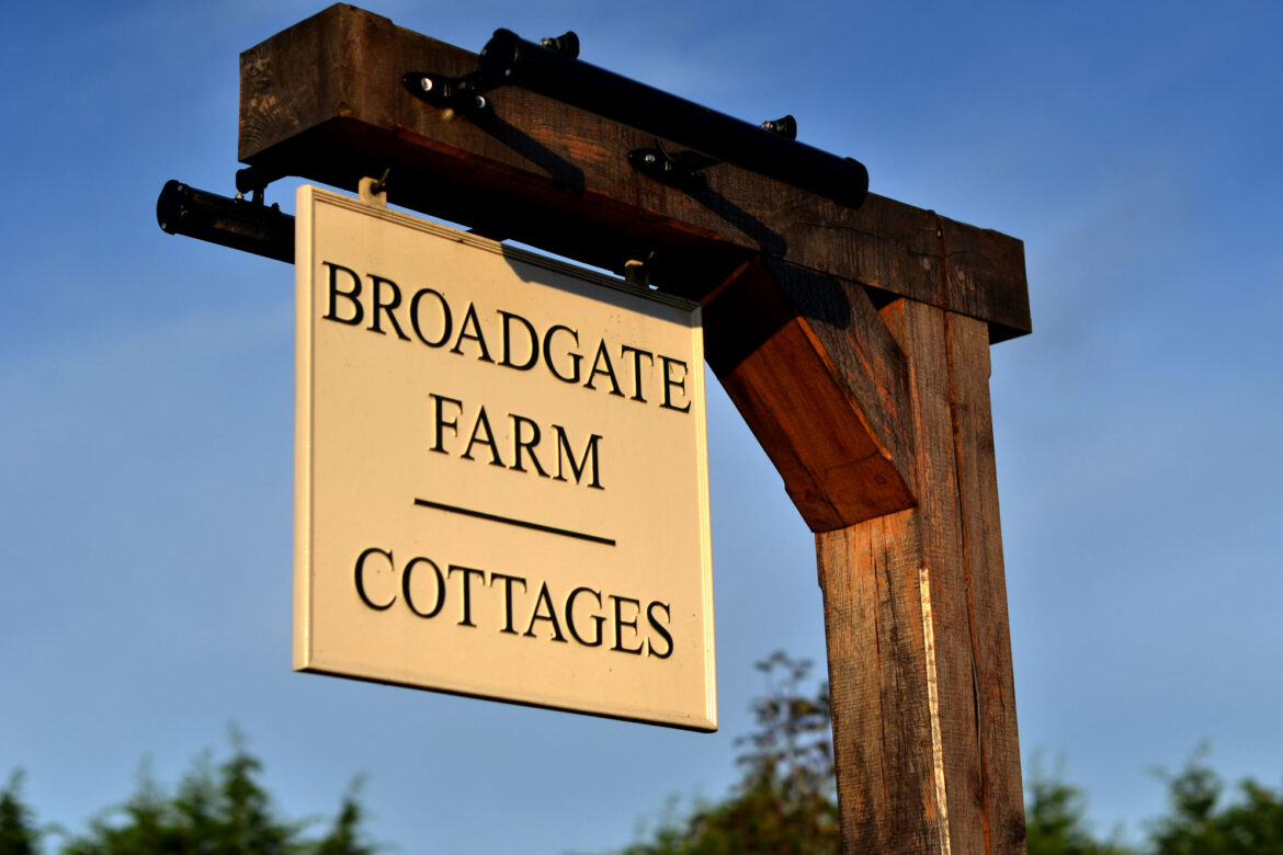 broadgate farm cottages sign in front of a blue sky