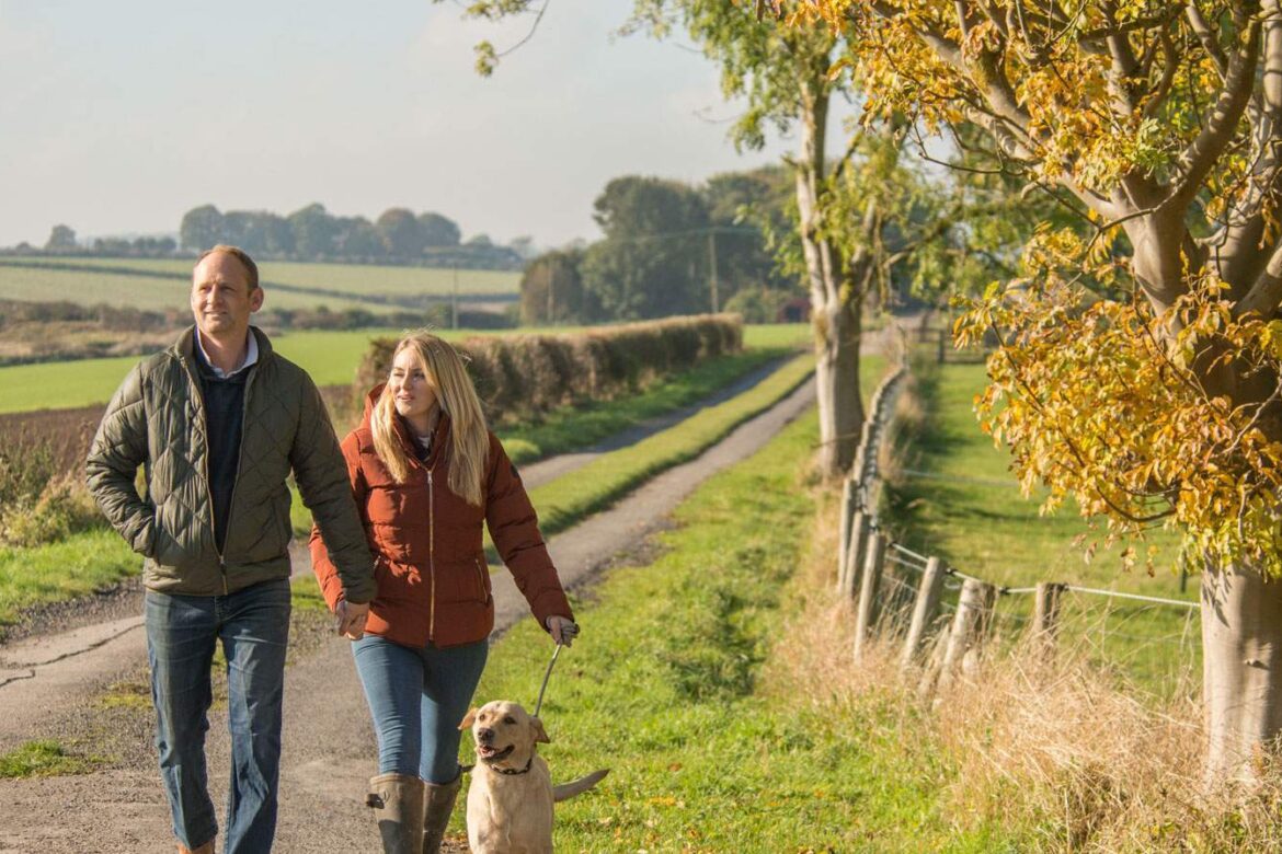 A couple walking with their dog in the Yorkshire Wolds - VHEY