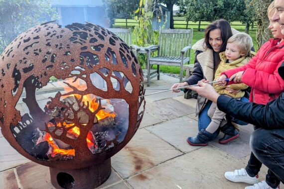 family roasting marshmallows around a firepit at broadgate farm holiday cottages near beverley 