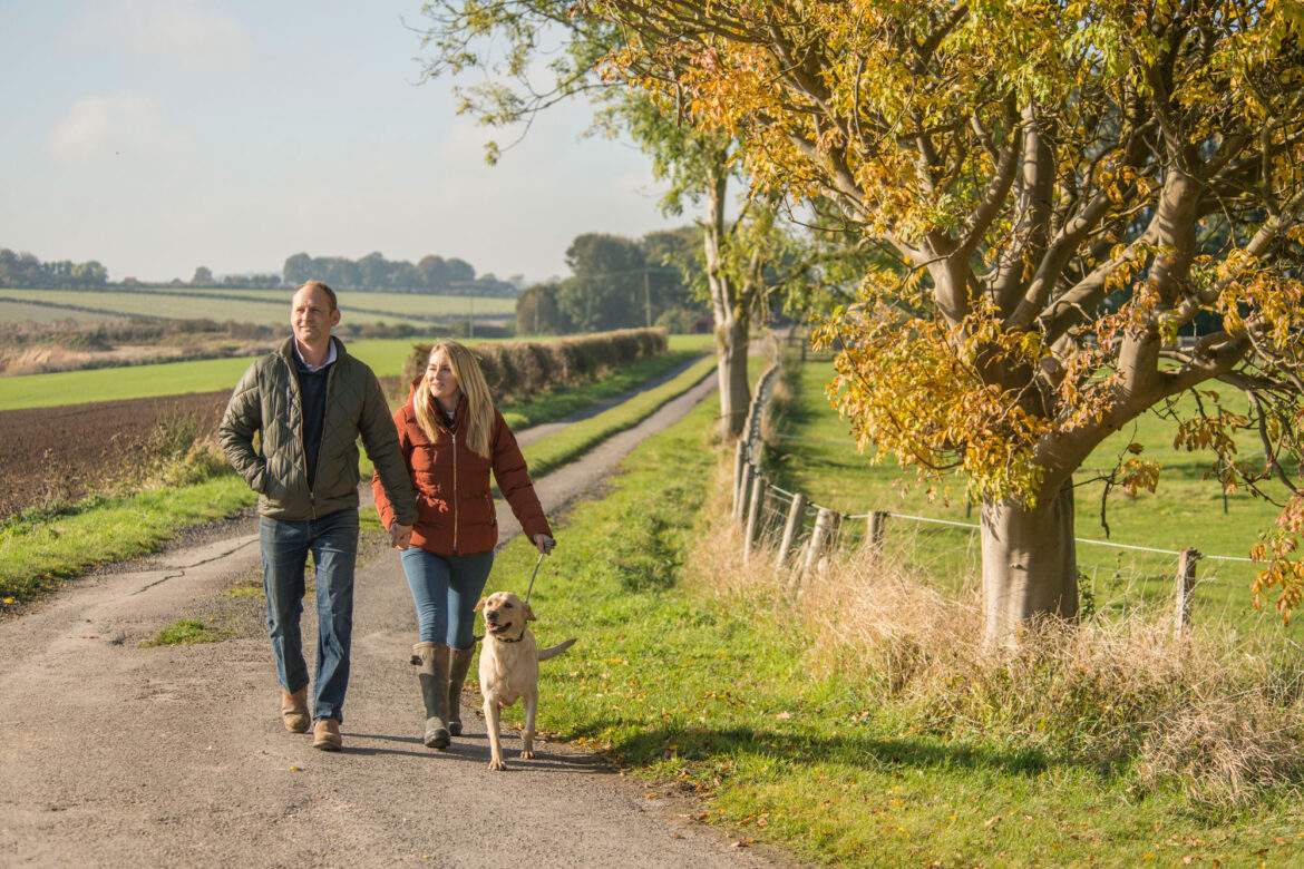 couple walking with dog in the countryside