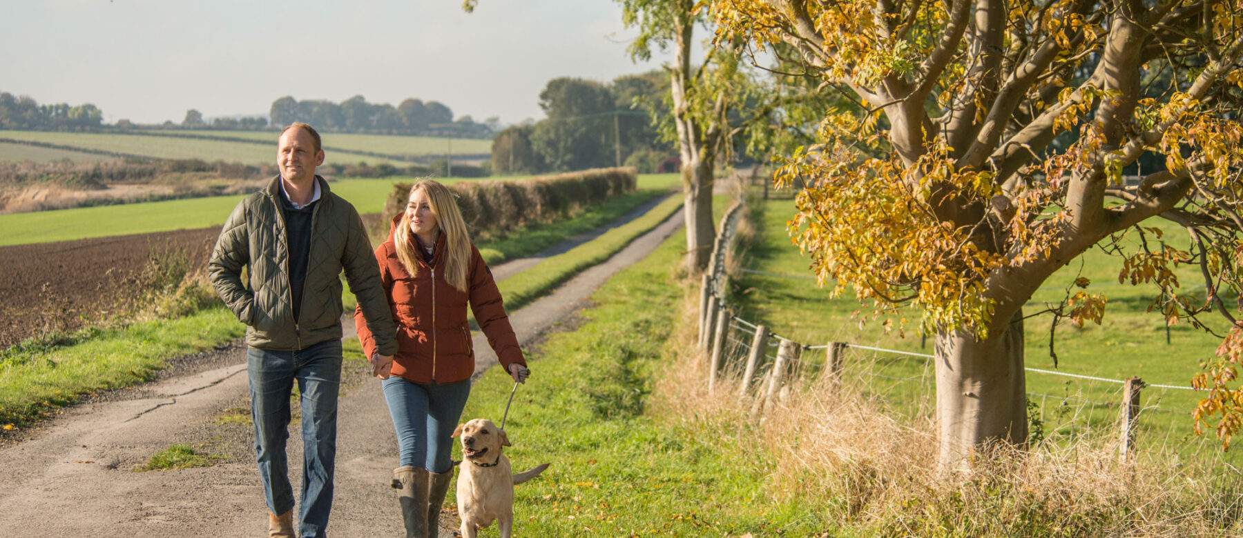 couple walking with dog in the countryside